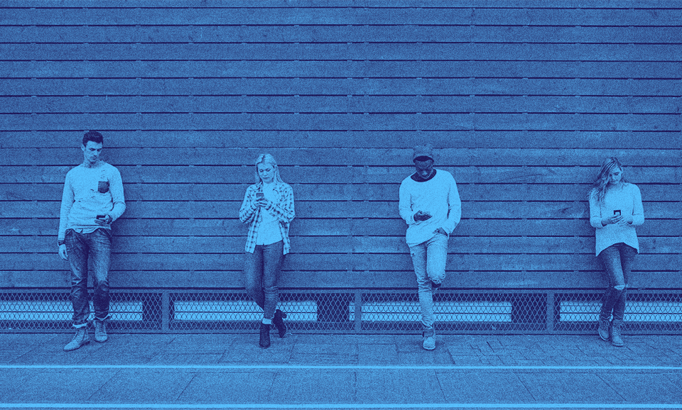 Four people leaning against a wall side by side.