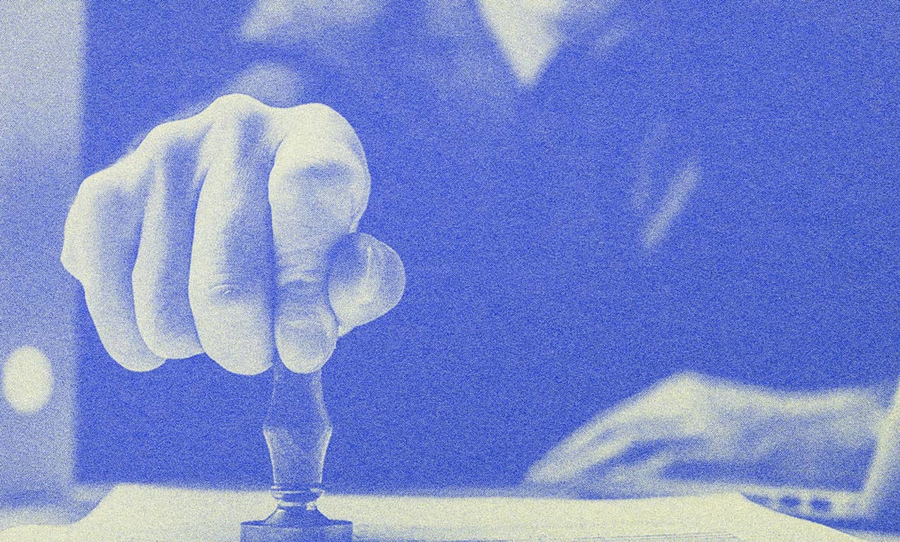 A man stamping on a piece of paper.