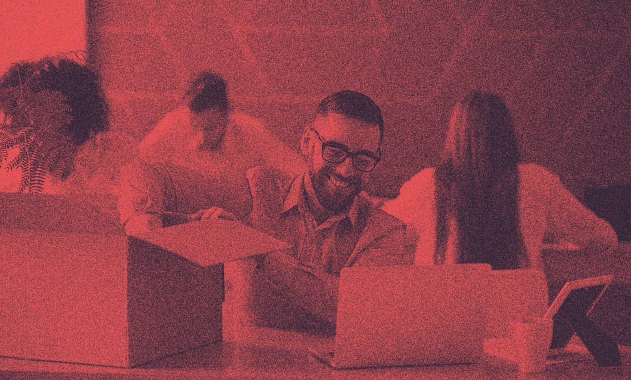 A man unpacking his box on a working desk.