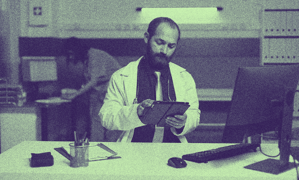 A doctor looking at his tablet.