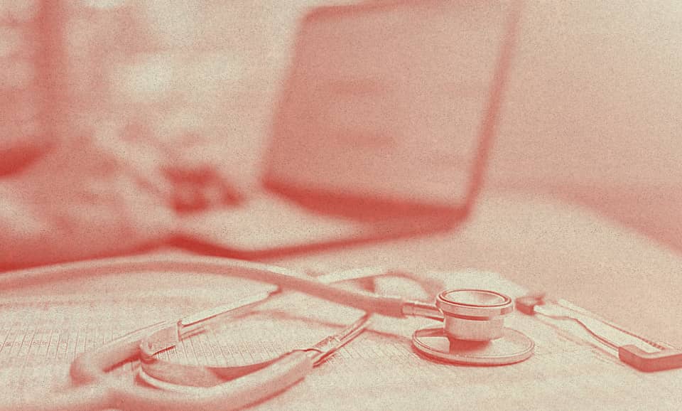 A stethoscope rests over what it seems to be an insurance contract.