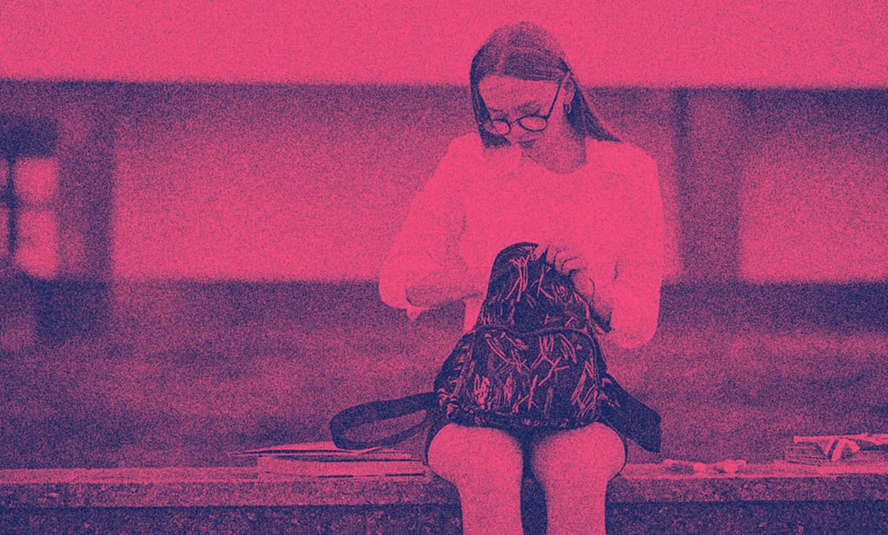 A female student sitting on a bench.