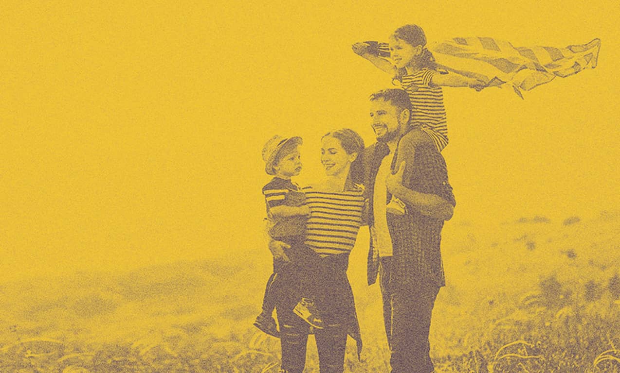 A family out on the fields, smiling.
