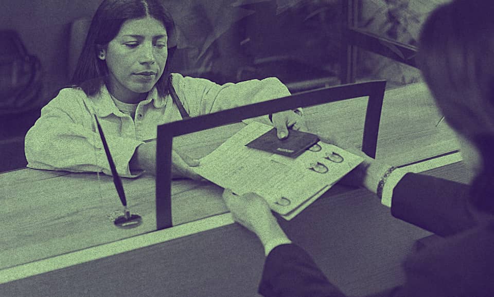 A woman is taking her files from an immigration office counter.