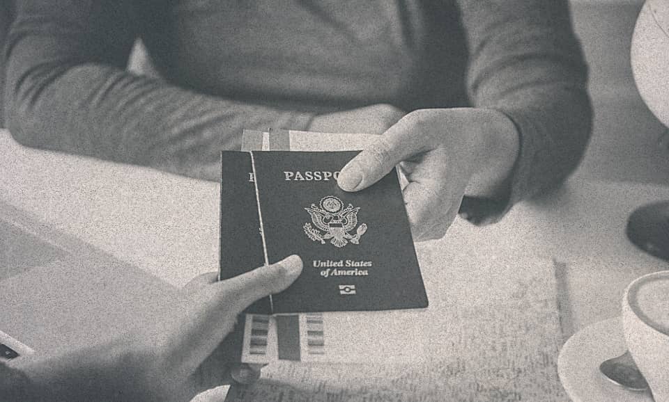 A person receiving his passport from some other person.