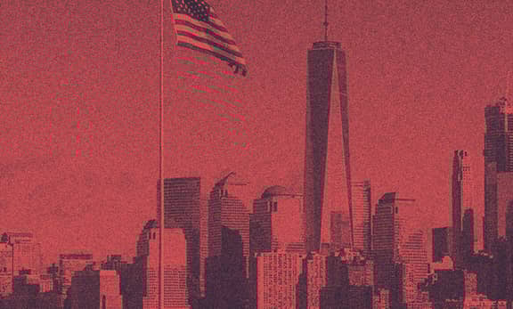 A view of the NYC with the USA flag hanging from above.