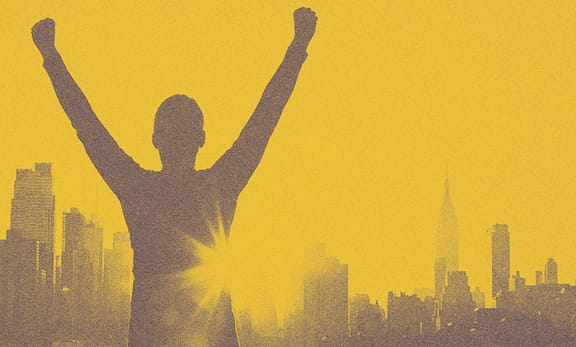 A person looking at the NYC with his arms up.