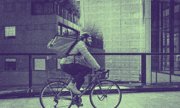 A person with a PERM Green Card riding a bike outside.