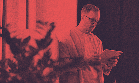 A person with an H-1B visa standing and looking at their iPad.