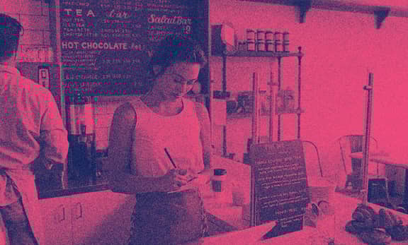 A barista in a coffee shop taking notes.