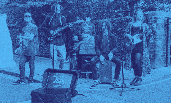 A music band performs on the sidewalk.