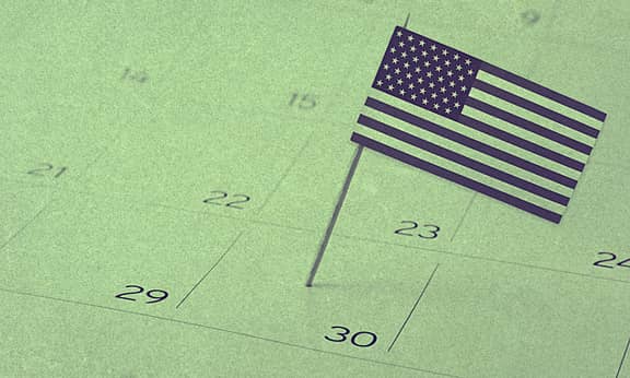 A mini U.S. flag planted on a calendar.
