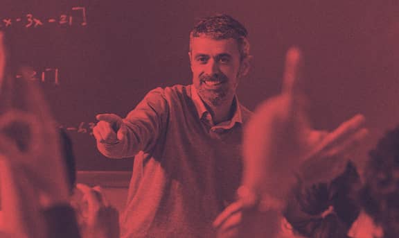 A lecturer in a class talking to his students.