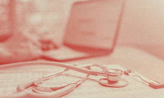 A stethoscope rests over what it seems to be an insurance contract.