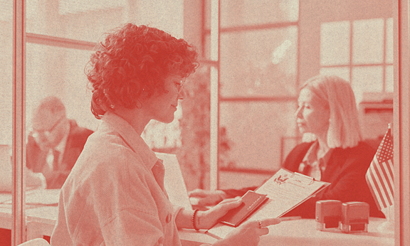 A person looks at a form smiling in an office space.