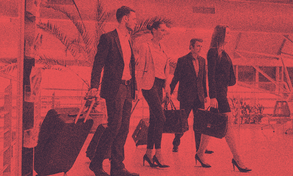 Business people in an airport, pulling their luggage.