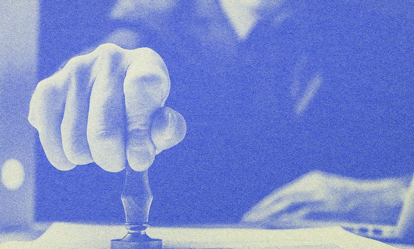 A man stamping on a piece of paper.