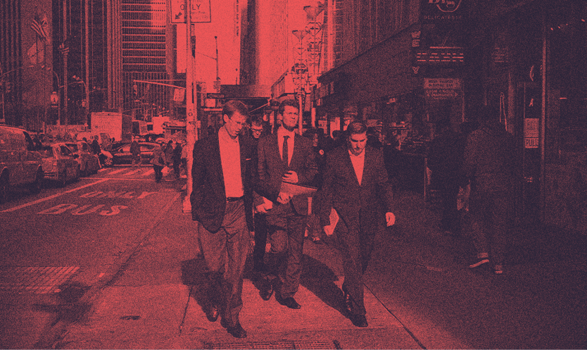 A group of men in suits walking on a street.