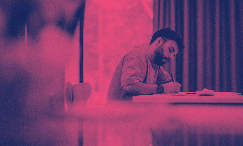 F1 öğrenci vizesiyle Amerika'da olan bir öğrenci kitabıyla ders çalışıyor.