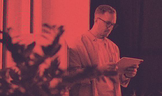 A person with an H-1B visa standing and looking at their iPad.