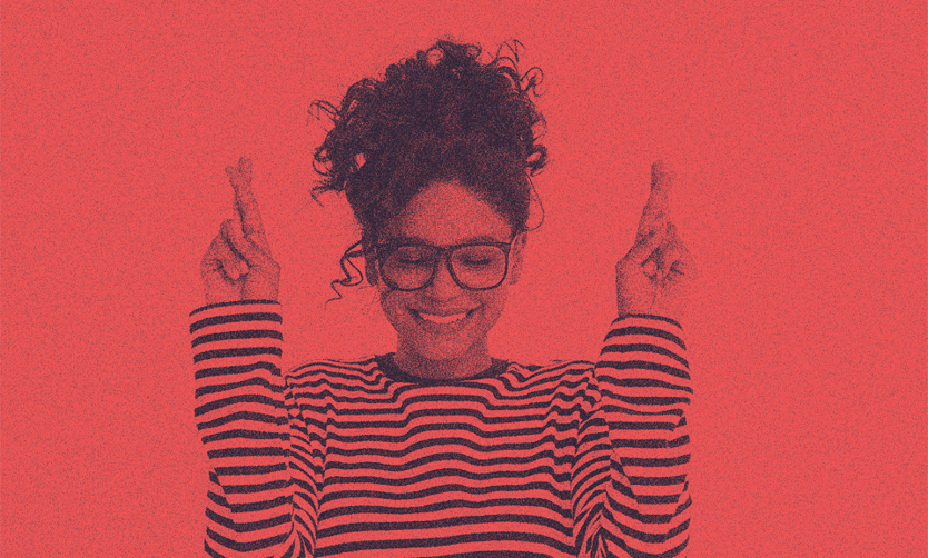 A woman is smiling with her hands up.