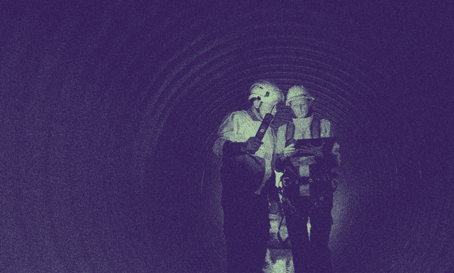 İki mühendis yer altında bir tablete bakıp konuşmaktalar.