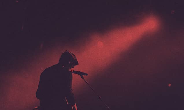 A musician on stage in front of a microphone.