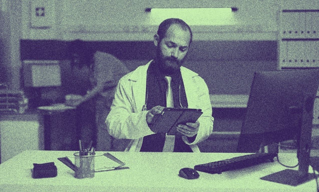 A doctor looking at his tablet.