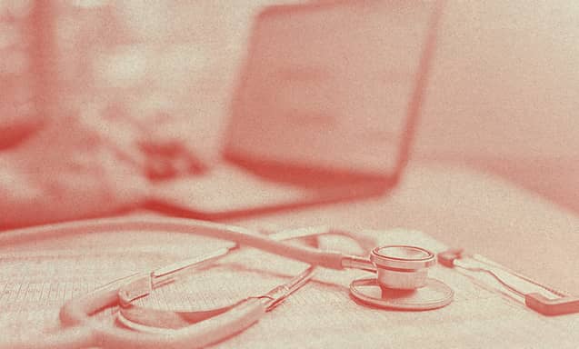 A stethoscope rests over what it seems to be an insurance contract.