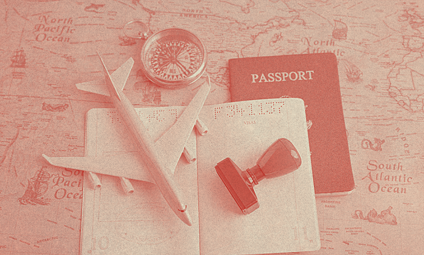 Açık bir Amerika pasaportu bir masanın üzerinde, maket bir uçakla birlikte.