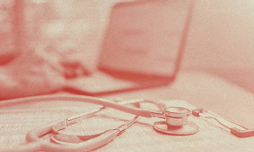 A stethoscope rests over what it seems to be an insurance contract.